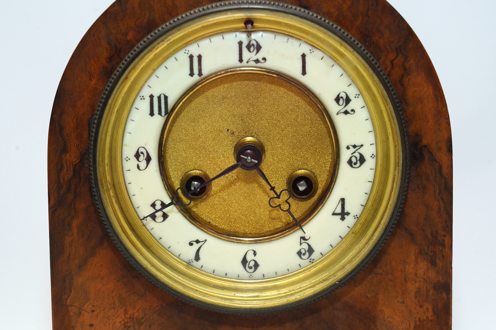 An Edwardian mantel clock with Arabic dial and applied plaque, 25cm high. Condition - fair to good, some cracking to the wood